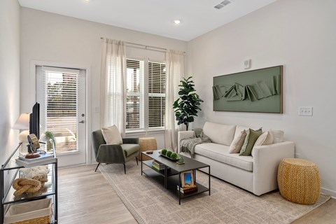 A living room with a white couch, a coffee table, and a large painting on the wall.