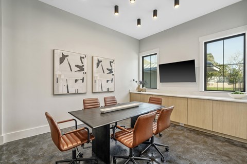 A conference room with a long table and chairs.