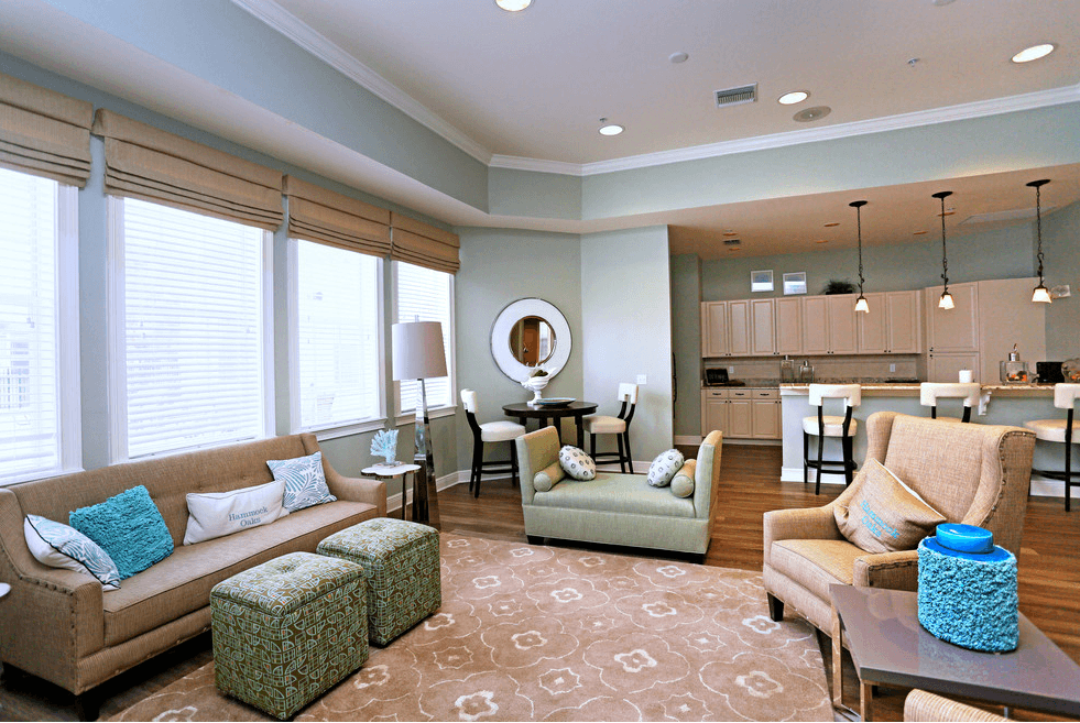 a living room with couches and chairs and a kitchen
