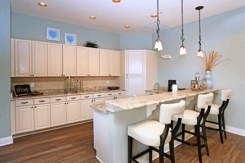 a kitchen with a bar and white cabinets