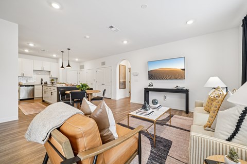 A modern living room with a brown leather chair and a white couch.