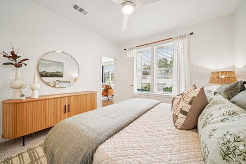 A bedroom with a large bed and a wooden cabinet.