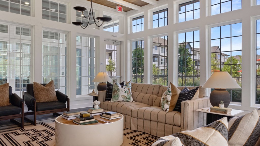 A living room with a large window and a sofa.