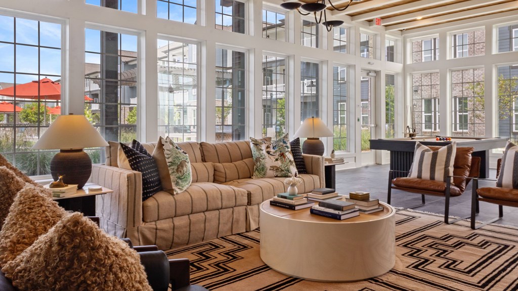 A living room with a large window and a brown couch.