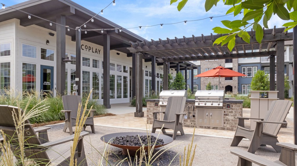 A patio area with chairs and a fire pit in front of a building with the sign "COPLAY".