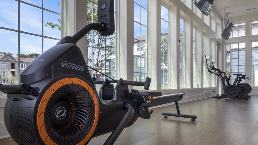 A stationary exercise bike is in a room with a view of the outside.