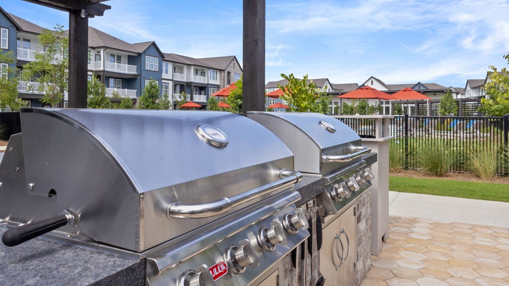 A row of LG grills are on a patio.