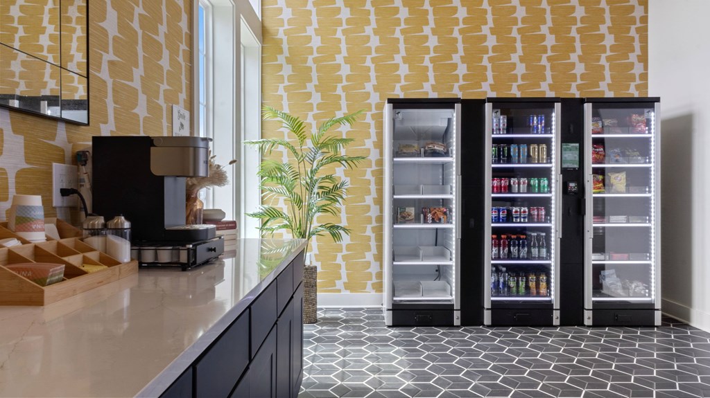 A kitchen with a black counter top and a yellow and white tiled wall.