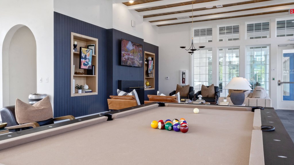 A pool table with a brown cloth and several pool balls on it.