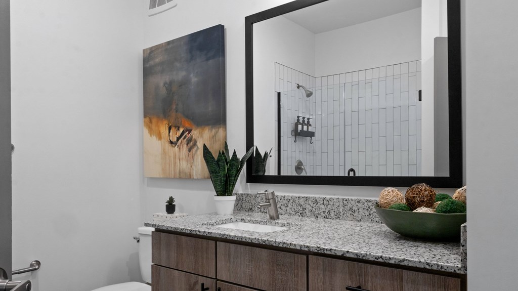 A bathroom with a large mirror and a painting on the wall.