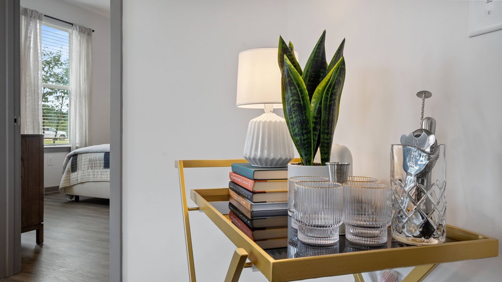 A table with a plant, books, and glasses on it.