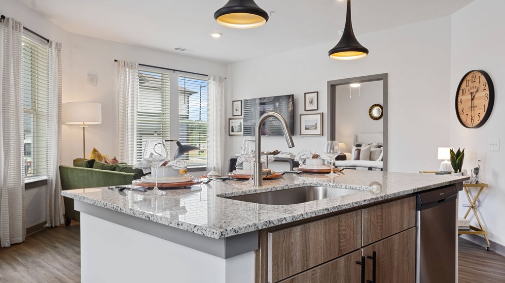 A modern kitchen with a large island and a clock on the wall.