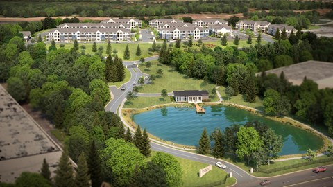 A large building complex with a pool in the middle of a green area.