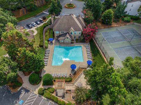A large house with a pool and tennis court.