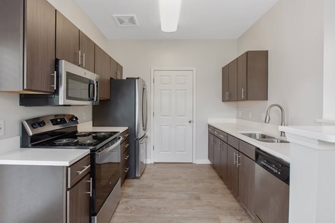 A kitchen with brown cabinets and stainless steel appliances.