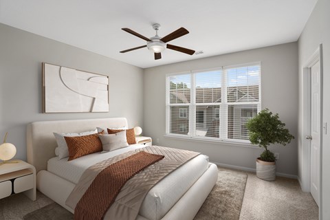 A bedroom with a large bed and a ceiling fan.