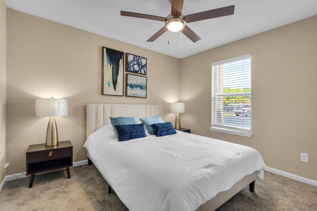 A bedroom with a ceiling fan and large window at Crystal Lake in Pensacola, Florida..