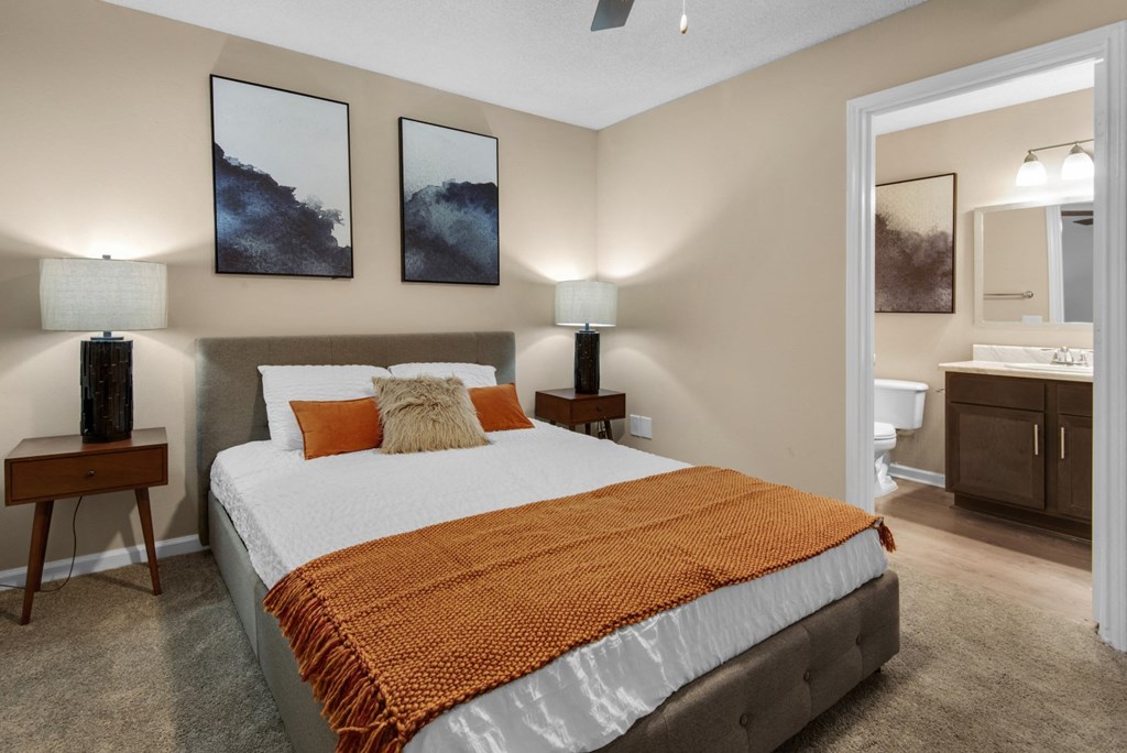 A bedroom with a connected bathroom and a ceiling fan at Crystal Lake in Pensacola, Florida.