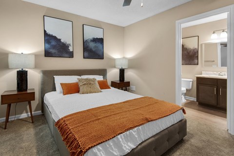 A bedroom with a connected bathroom and a ceiling fan at Crystal Lake in Pensacola, Florida.