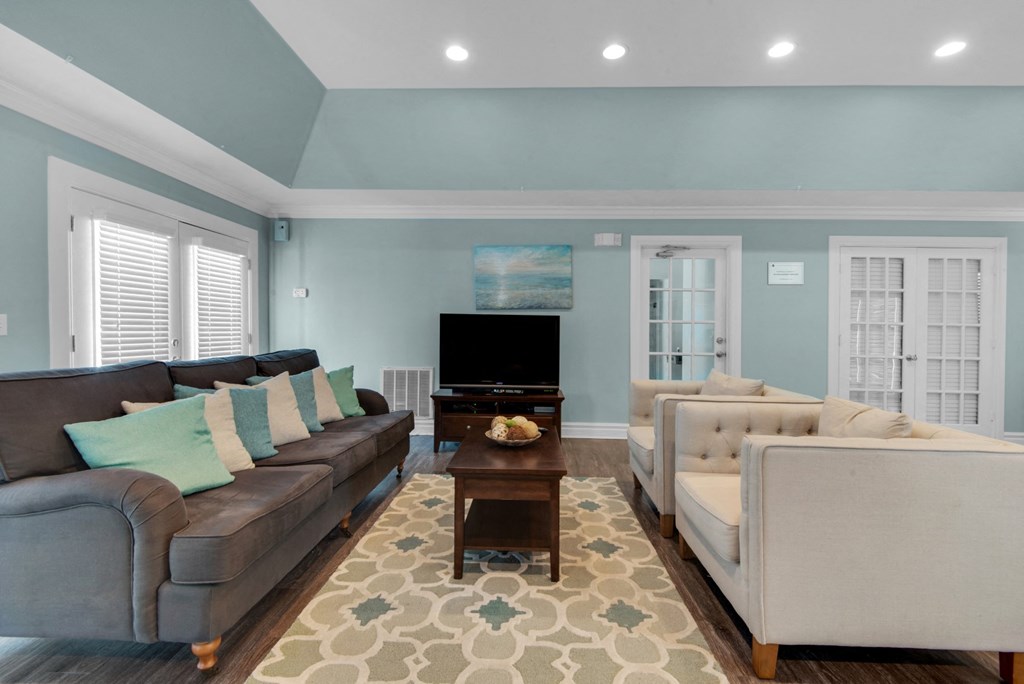 Lounge area in the clubhouse with couches and a TV at Crystal Lake in Pensacola, Florida.