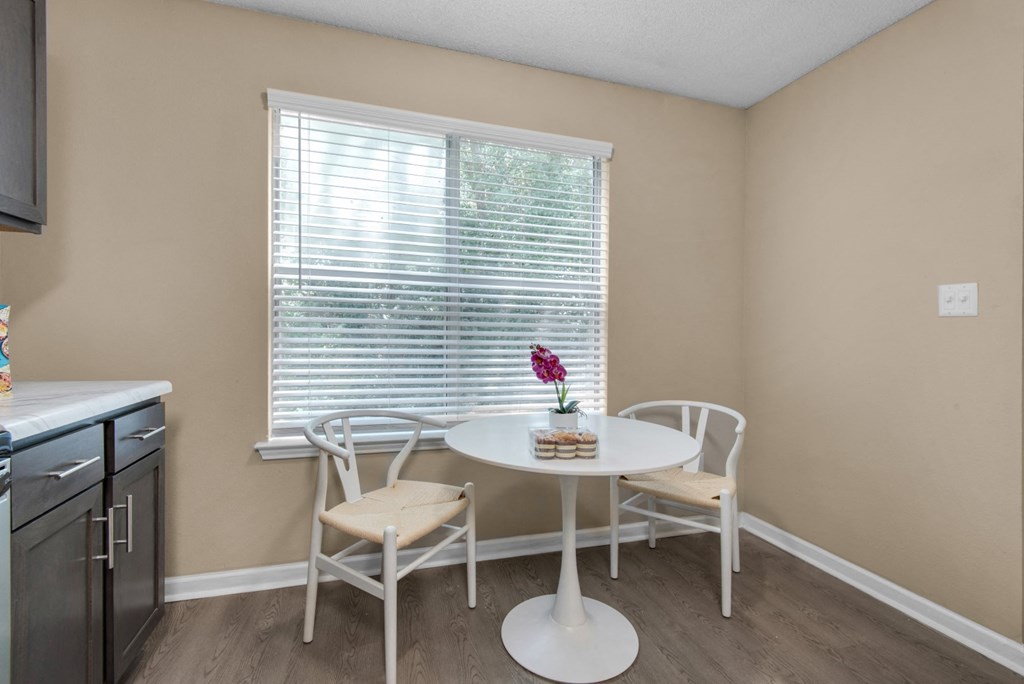 A dining area with wood flooring and a large window at Crystal Lake in Pensacola, Florida.