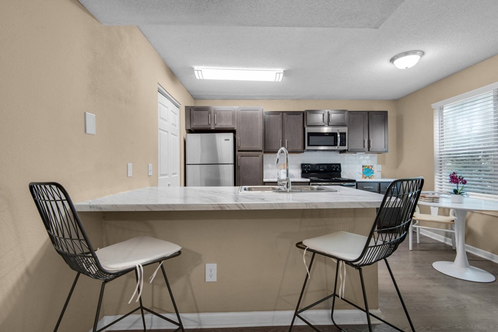 A kitchen with a white granite countertop and stainless-steel appliances at Crystal Lake in Pensacola, Florida.