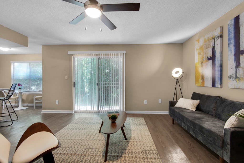 A living room with a ceiling fan and a sliding door at Crystal Lake in Pensacola, Florida..