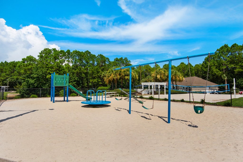 An outdoor playground with swings and a slide at Crystal Lake in Pensacola, Florida.
