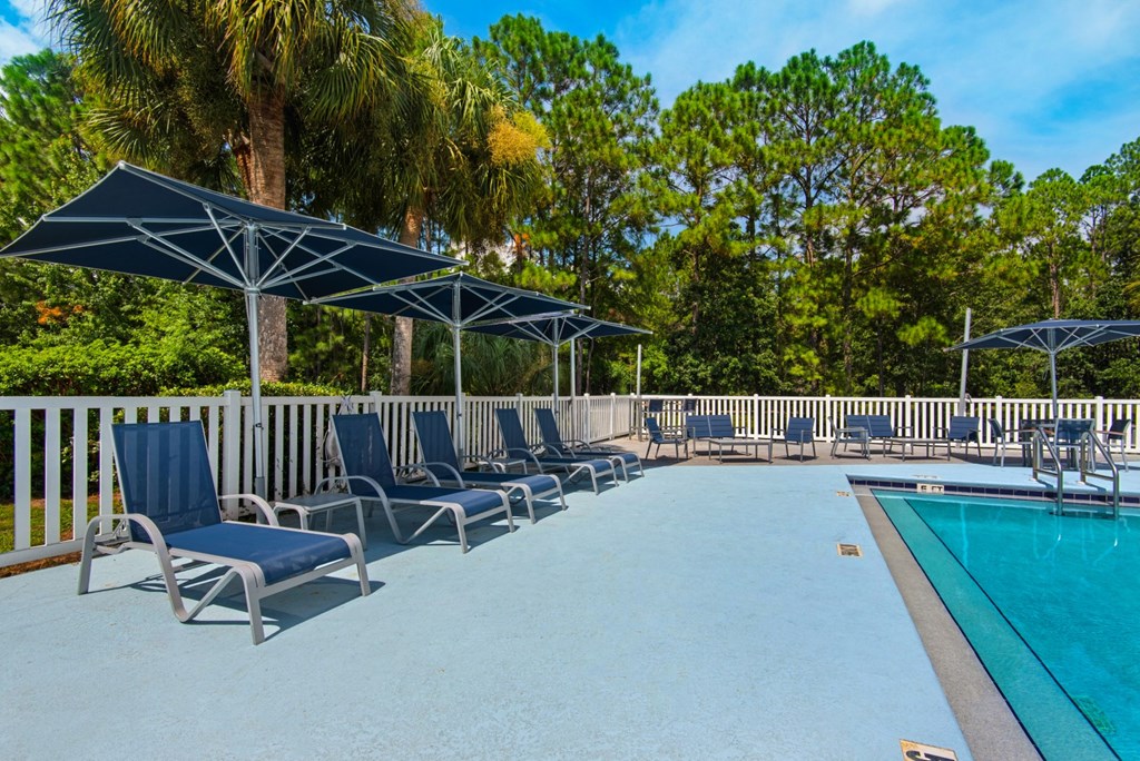 Sun loungers and umbrellas that surround the outdoor pool at Crystal Lake in Pensacola, Florida.