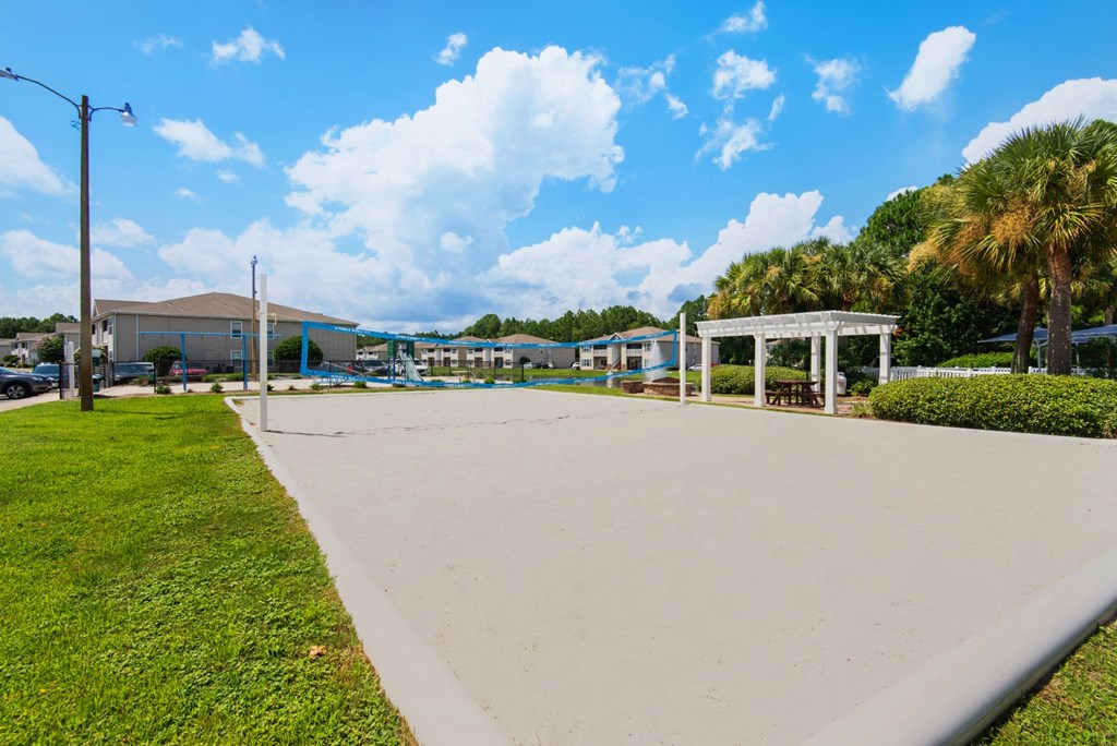 A sand volleyball court with a pavilion on the perimeter at Crystal Lake in Pensacola, Florida.