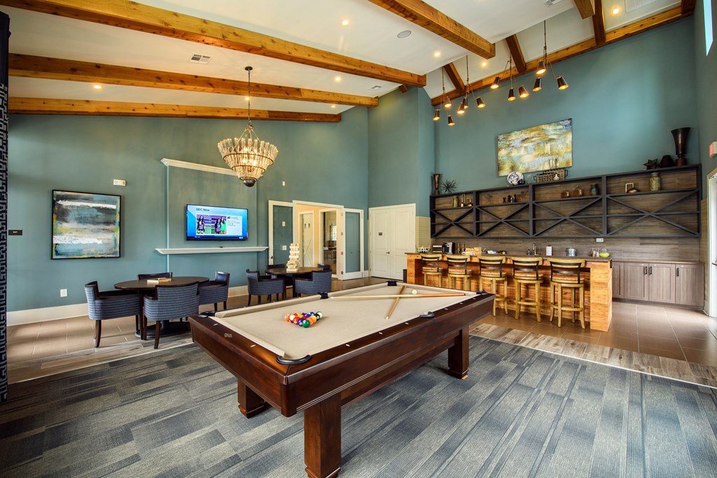 a game room with a pool table and a bar