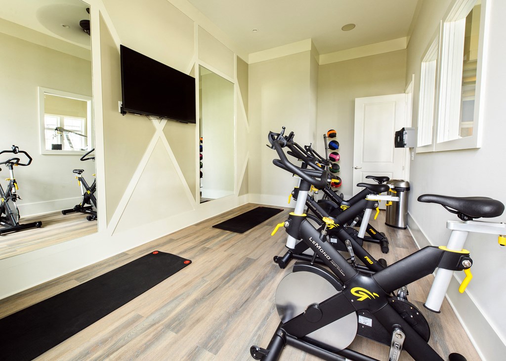 a spin class room with exercise bikes and a tv