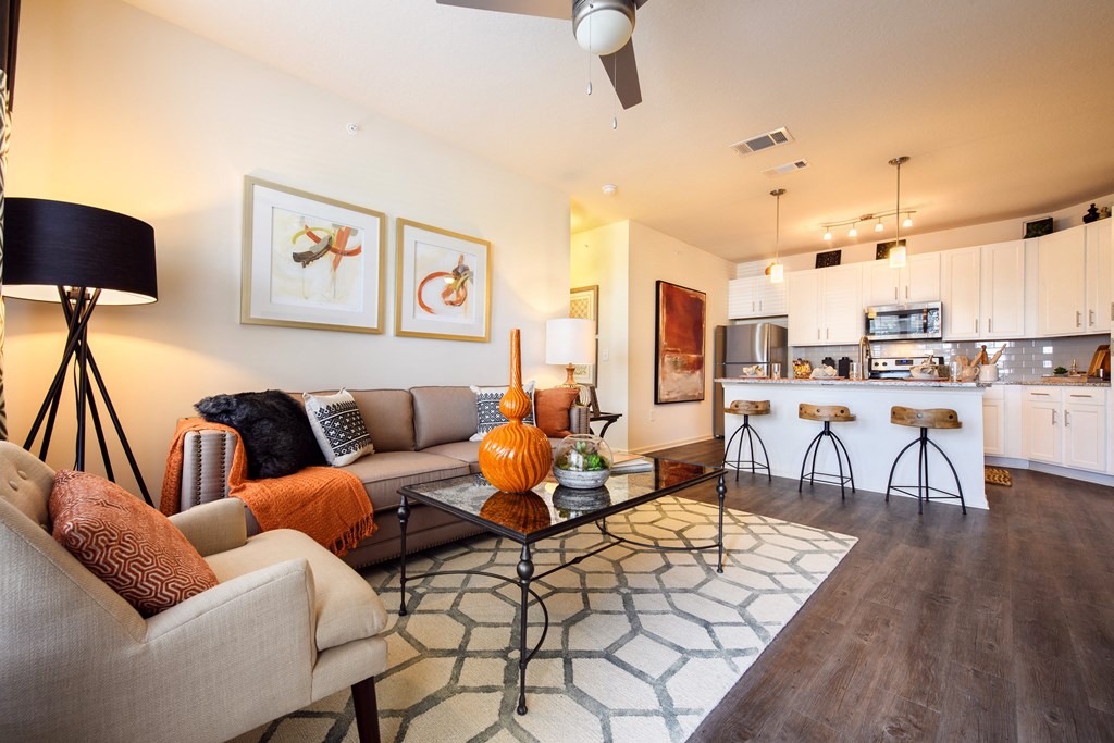 a living room with a couch and a coffee table and a kitchen
