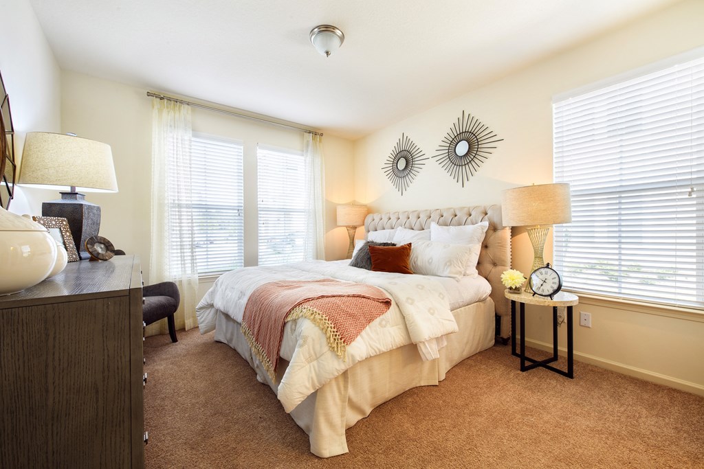 a bedroom with a bed and two windows