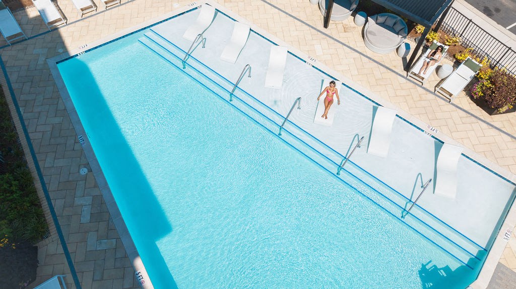 an aerial view of a swimming pool with two people in it