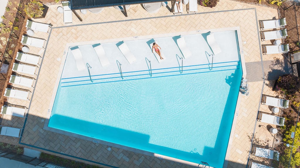 an aerial view of a swimming pool with people in the water