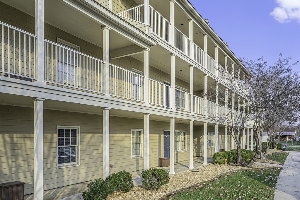 an exterior view of a yellow building with white balconies