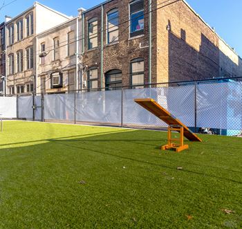 a picnic bench on the grass in front of a fence