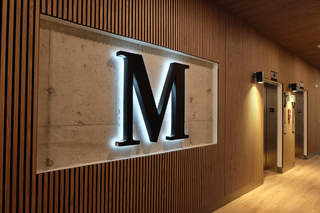 a large metal letter m on the side of a building