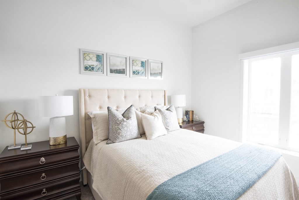 a bedroom with a bed and two nightstands and a window at 20 Midtown, Birmingham, Alabama