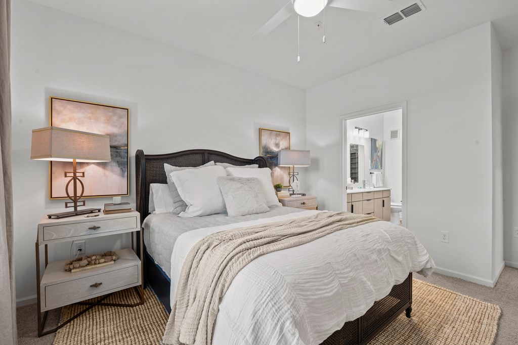 A bedroom with a large bed and a ceiling fan.