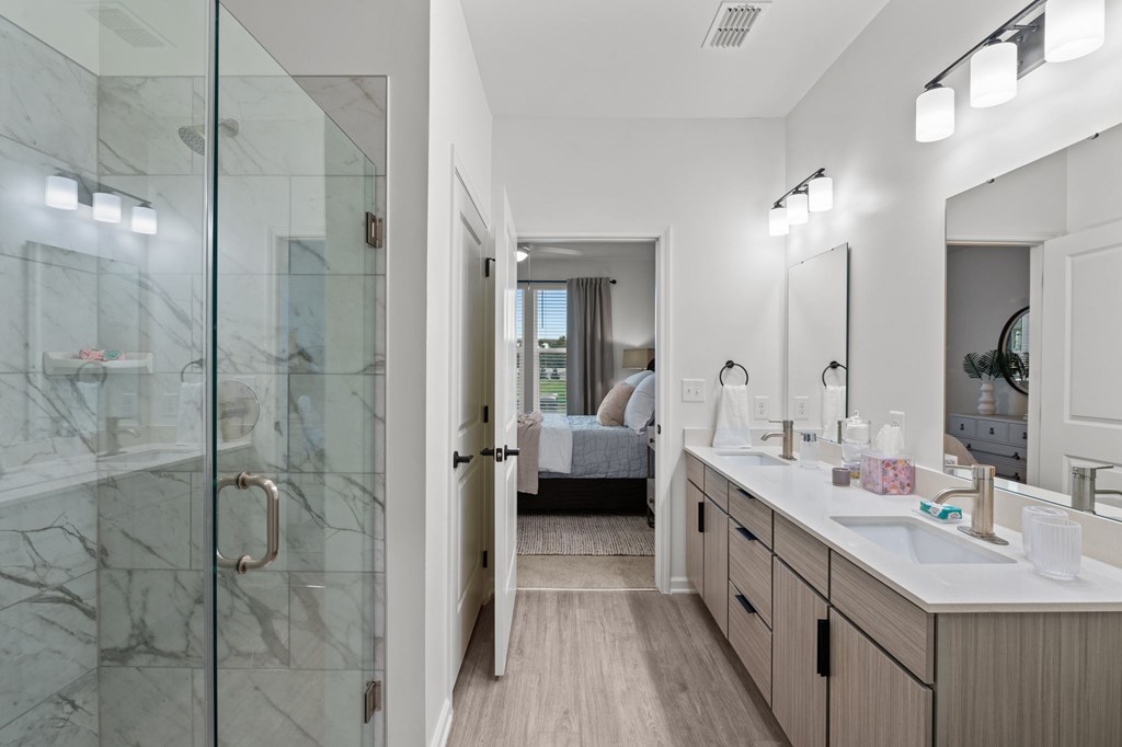 A bathroom with a walk-in shower and a vanity with a mirror.