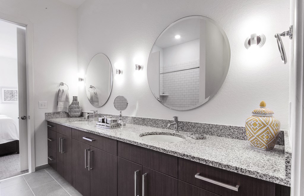a bathroom with two sinks and two mirrors at 20 Midtown, Birmingham, Alabama