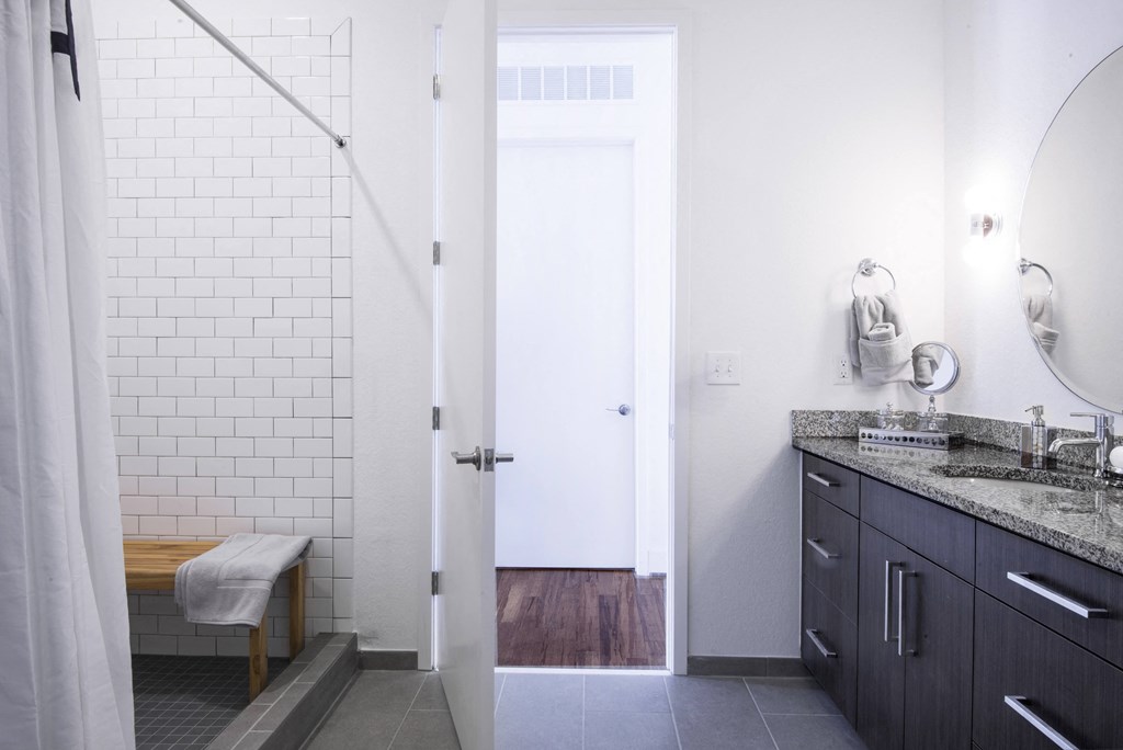 a bathroom with a shower and a sink and a mirror at 20 Midtown, Alabama, 35233