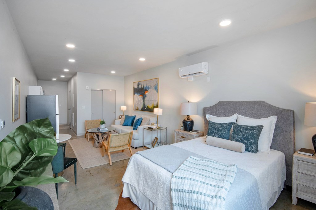 a bedroom with a large bed and a living room