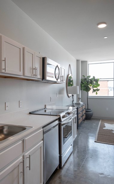 a kitchen with white cabinets and stainless steel appliances
