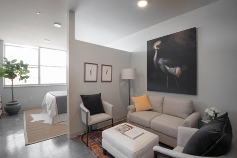 a living room with a couch and a painting of a crane