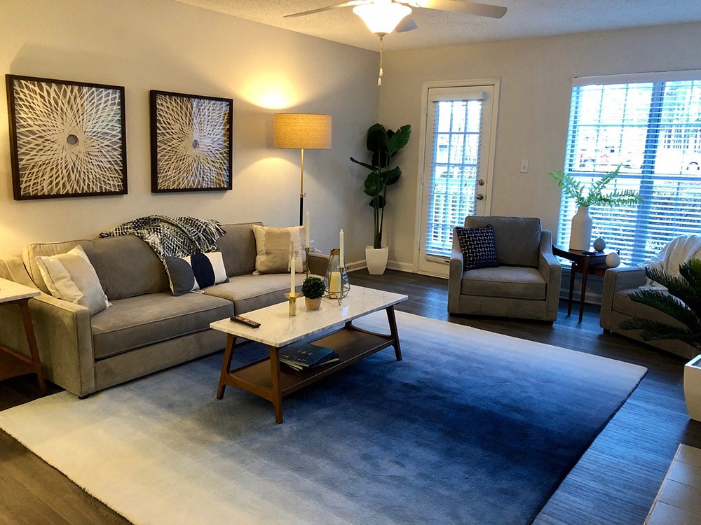 a living room with couches and chairs and a blue rug