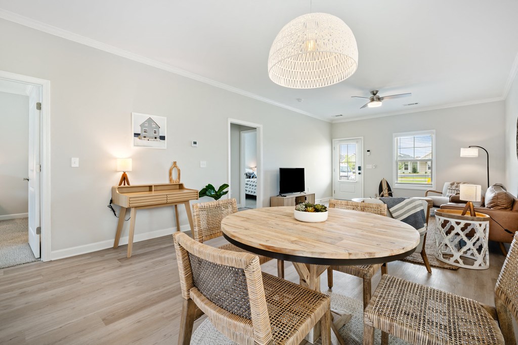a living room and dining room with a table and chairs at The Cottages at Foley Farms apartments in Foley, AL