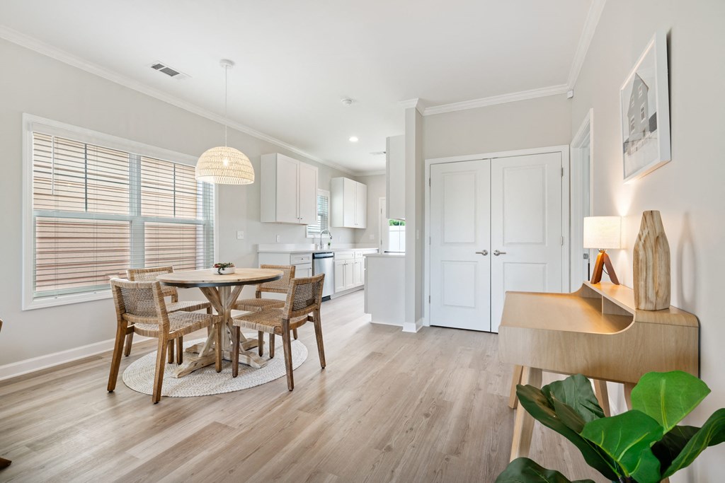 a dining room and kitchen with a table and chairs at The Cottages at Foley Farms apartments in Foley, AL